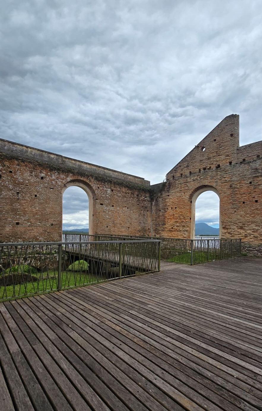 Interior do Armazém Macedo em Antonina PR — arcos de tijolos com vista para a Serra do Mar